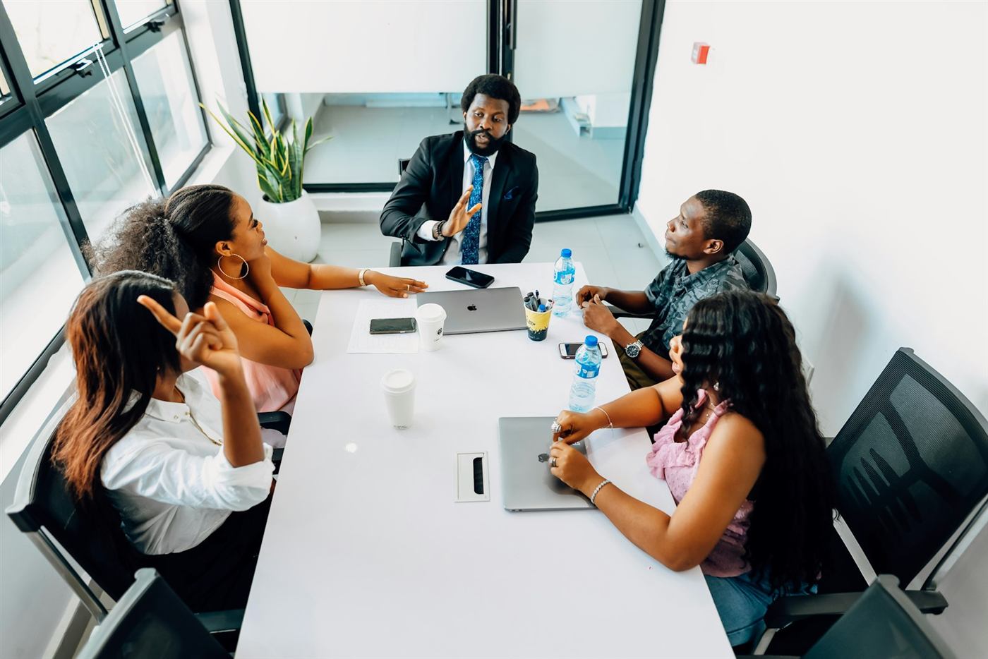 A manager leading a team meeting around a boardroom table
