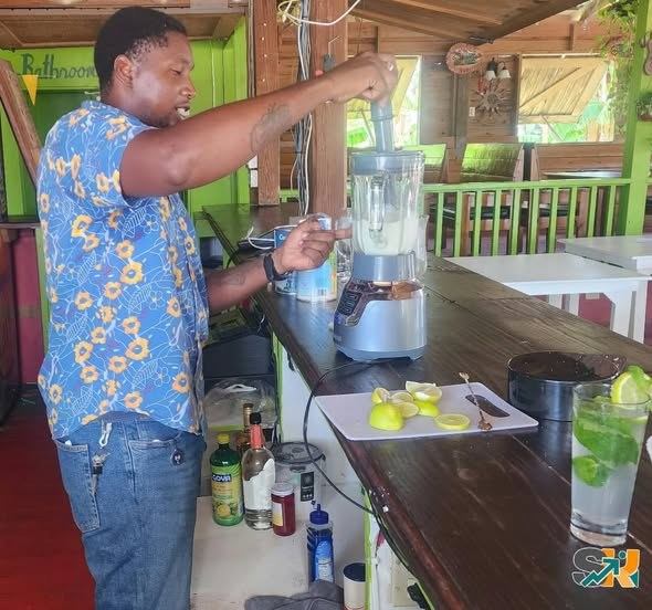 A facilitator demonstrating drink preparation at a bar