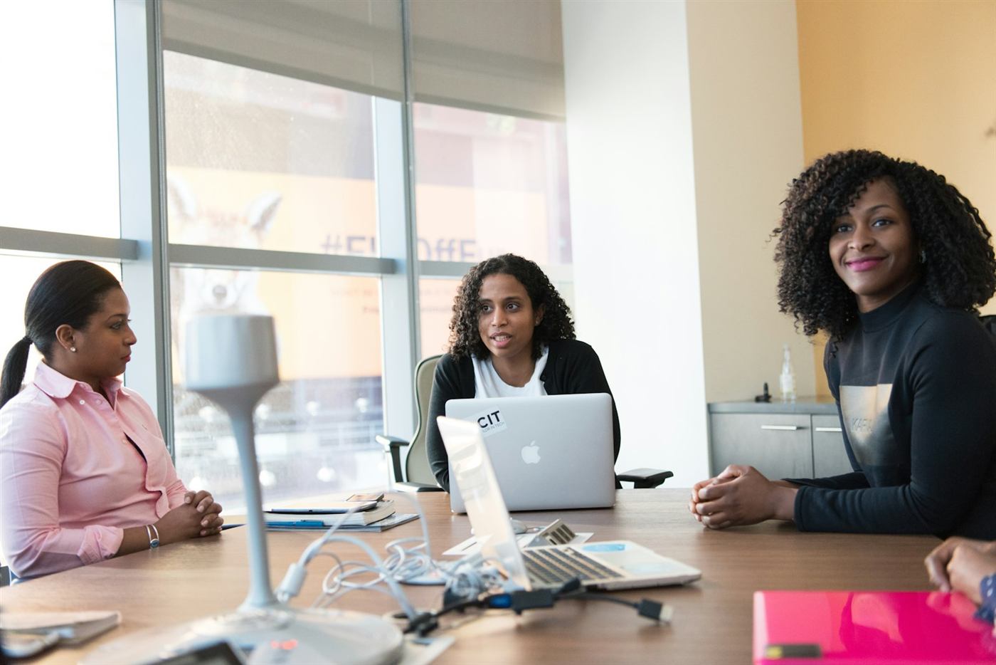 Three professionals talking at a meeting table